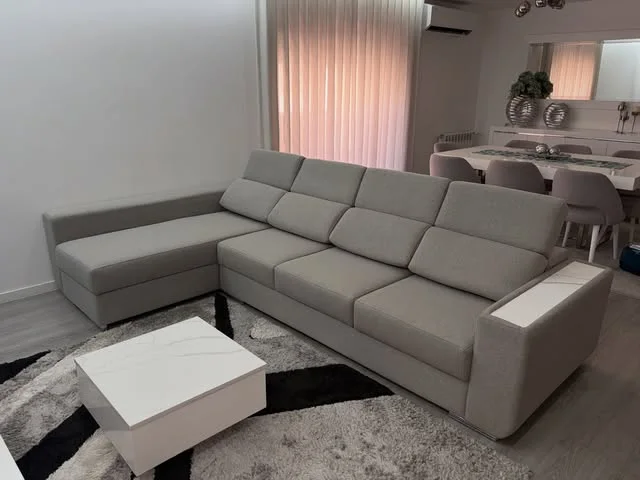 Sofá de canto cinzento com mesa de centro branca