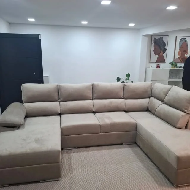 Sofá de canto em U, em tecido bege, numa sala